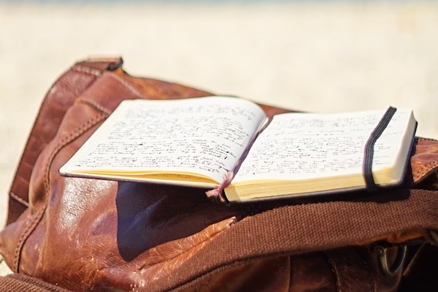 notebook on top of a bag on a beach