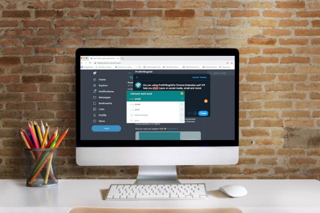 chrome extension in twitter on a desktop screen in front of a brick wall