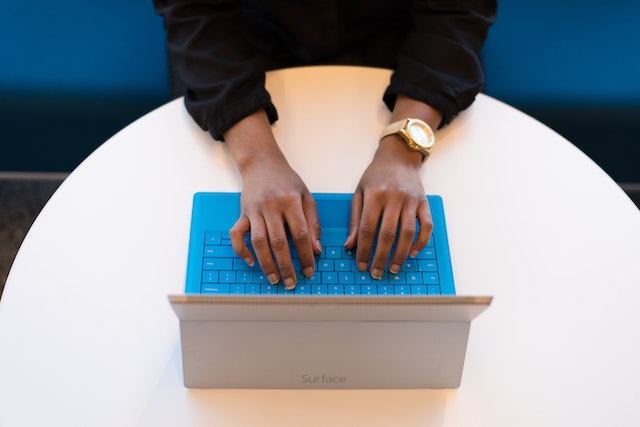 woman typing on a laptop from above