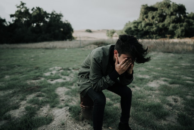 defeated man with face in hands