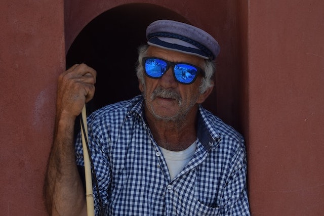 old man resting with walking stick