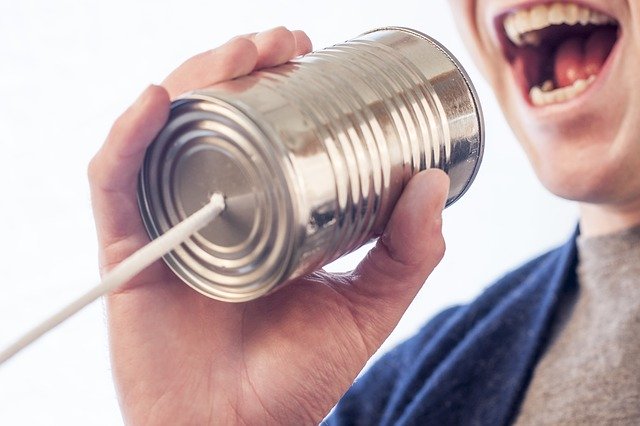 happy man speaking into a tin can phone