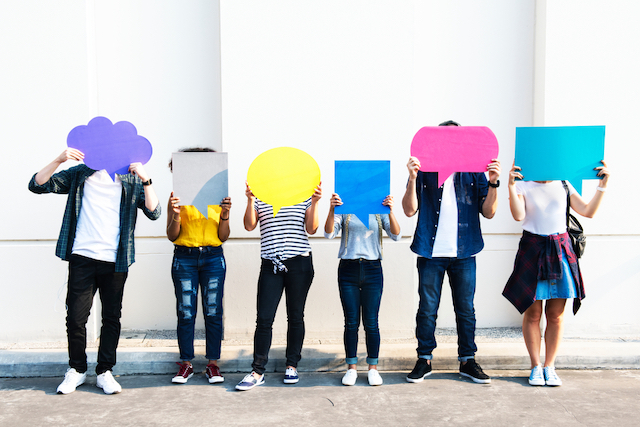 people holding different shaped speech bubble cut-outs