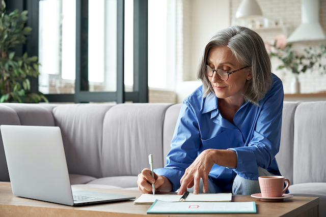 woman writes notes while editing manuscript