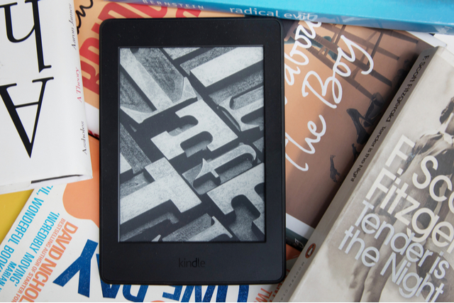 a kindle on a pile of books