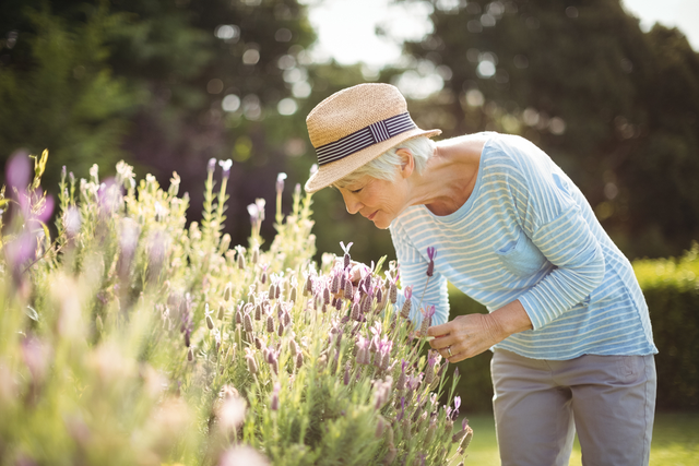 a woman smells flowers in a garden