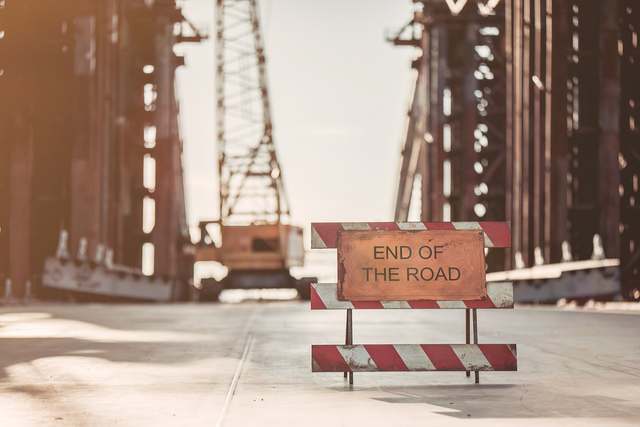 View of unfinished construction on the street. Warning about the end of the road.