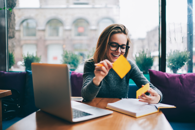 writer using post-it notes, smiling